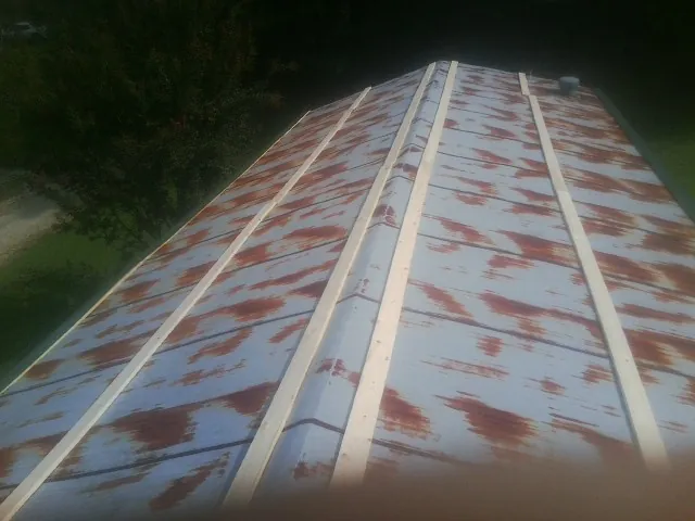Rusted metal roof panels with new wood purlins before replacement — Storm Damage Roof Repair in Riddle by Roofing Brothers
