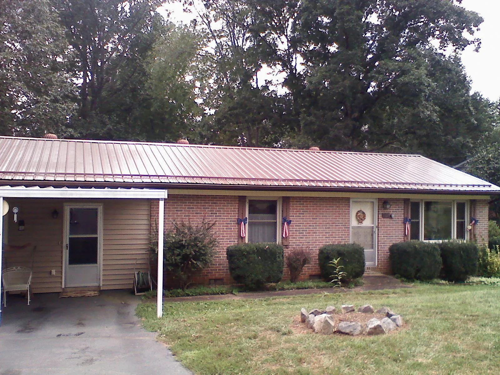 Bronze metal roof and carport on a brick ranch home — Roof Repair work by our crew in Riddle