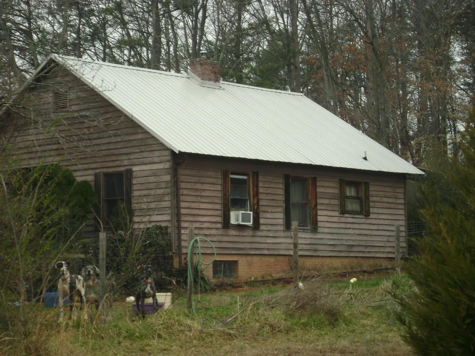White metal roof on an old wood sided farmhouse, from a Metal Roof Installation job in Riddle